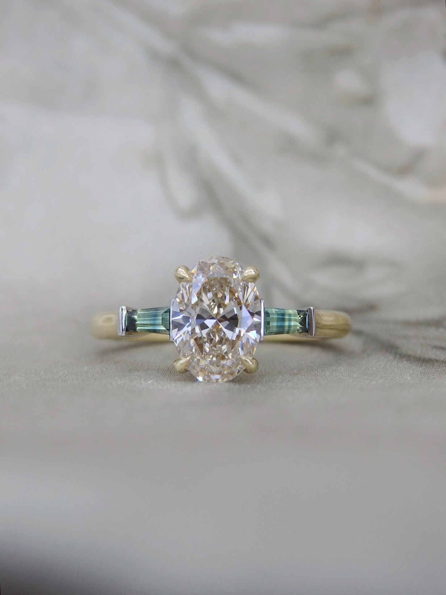 Oval Champagne Diamond Trilogy Ring with Parti Sapphire tapered baguette side stones in yellow gold and platinum