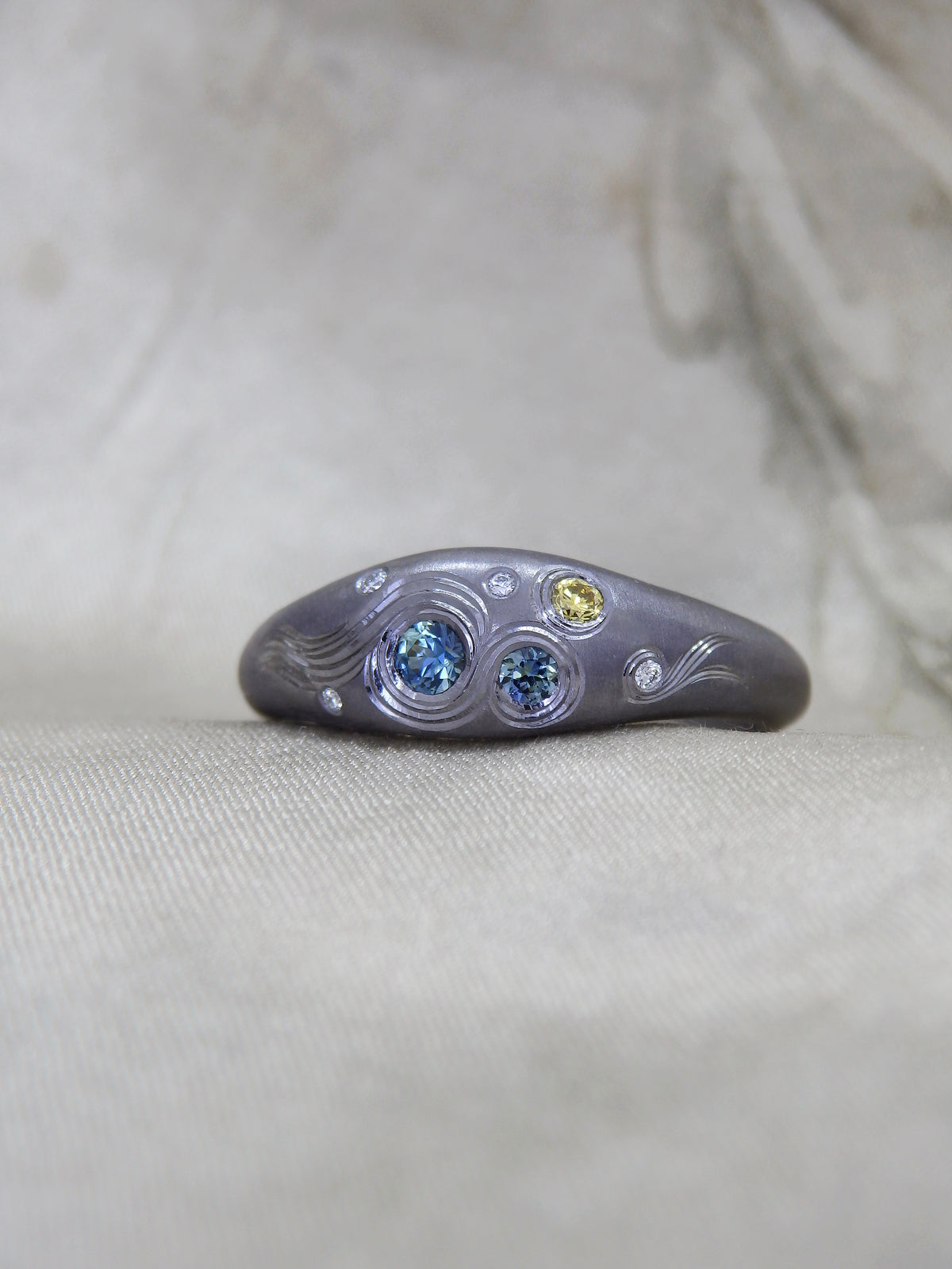 Hand Engraved black Tantalum Ring with australian parti sapphires and natural diamonds in a high domed tapering profile. Hand engraved yellow diamond crescent moon
