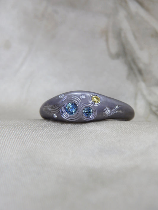 Hand Engraved black Tantalum Ring with australian parti sapphires and natural diamonds in a high domed tapering profile. Hand engraved yellow diamond crescent moon