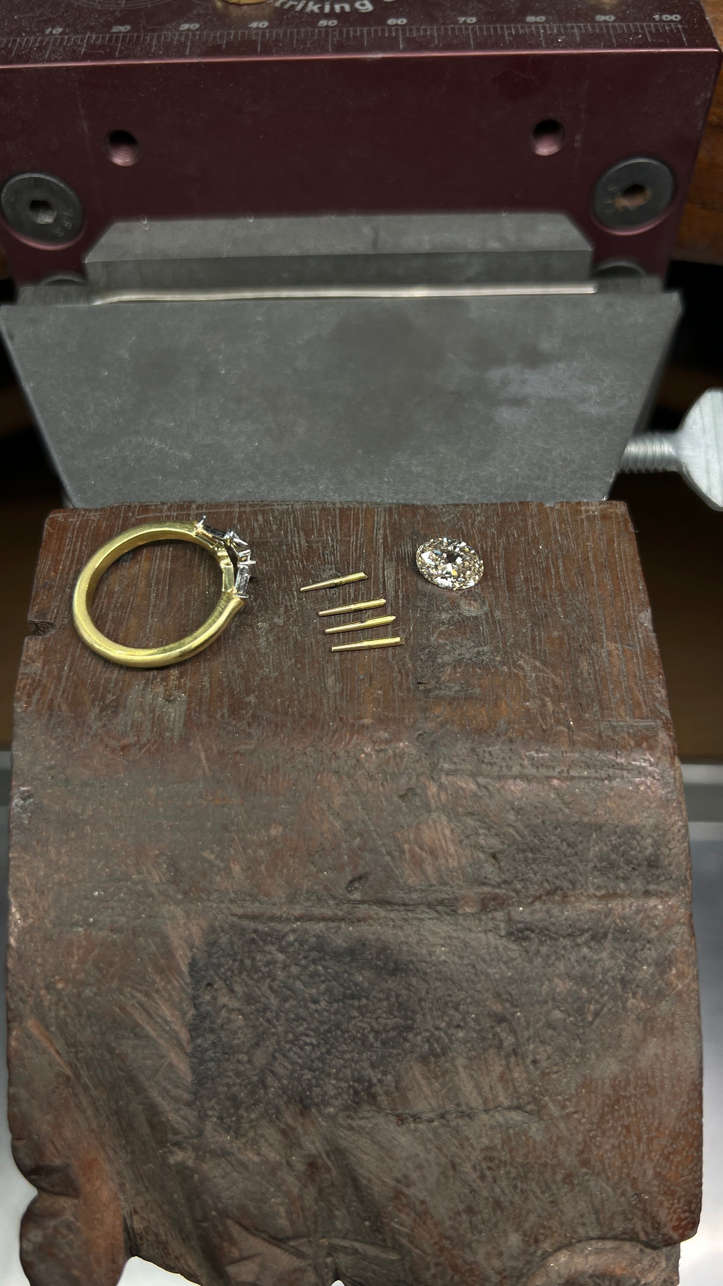 production shot mid-making of a custom three stone engagement ring with a champagne diamond 