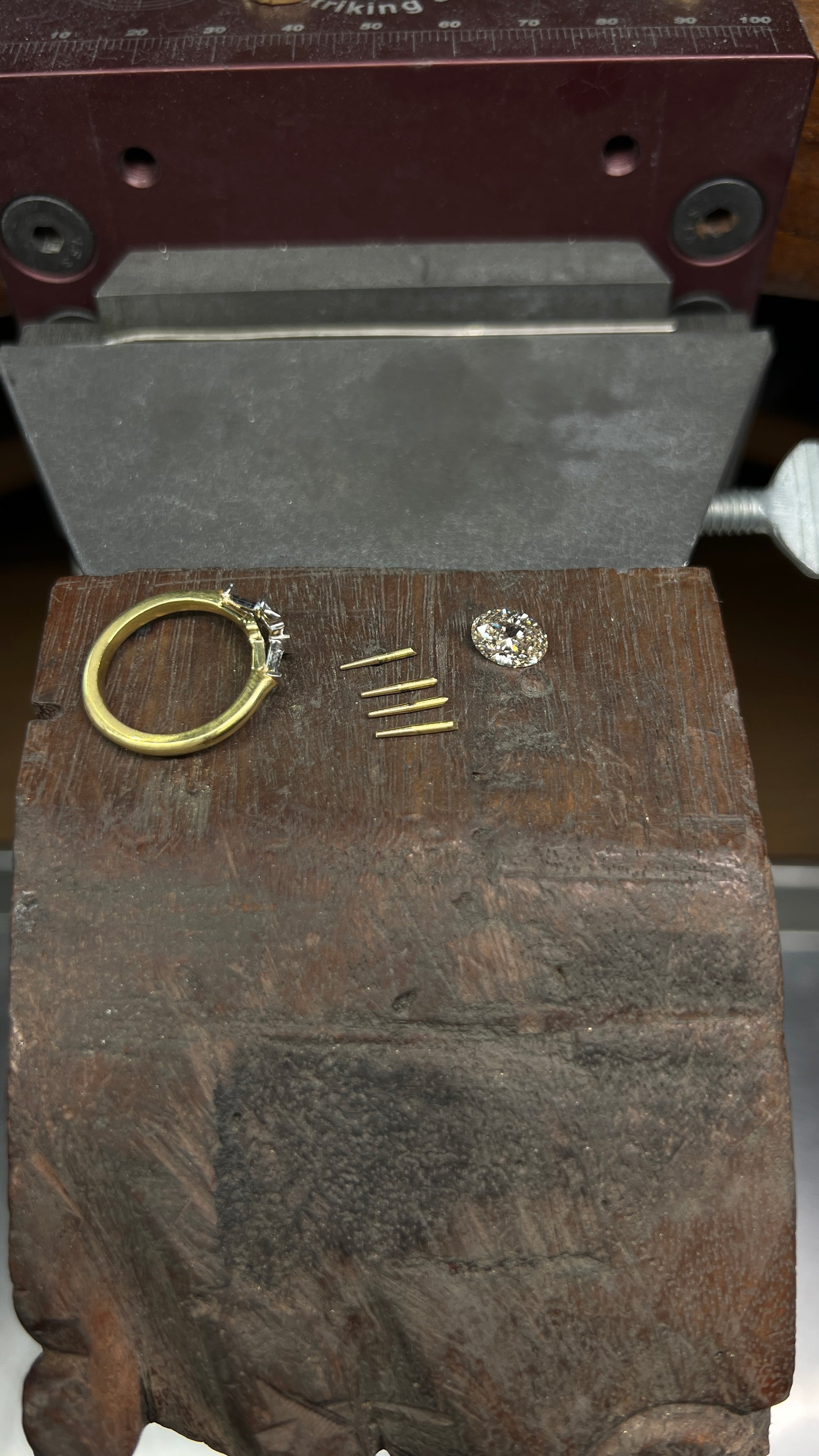 production shot mid-making of a custom three stone engagement ring with a champagne diamond 