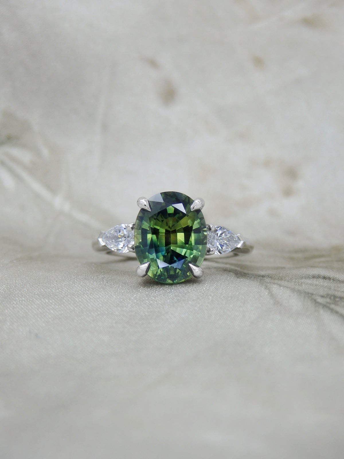 Big oval teal parti sapphire trilogy engagement ring with natural pear shape diamond side stones handmade in platinum