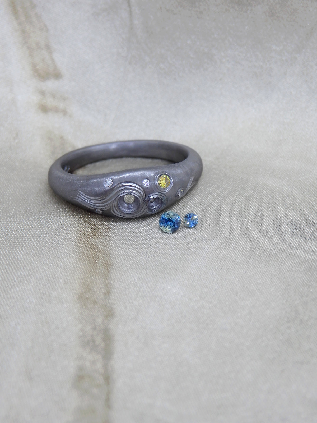 Hand Engraved black Tantalum Ring with australian parti sapphires and natural diamonds in a high domed tapering profile. Hand engraved moon