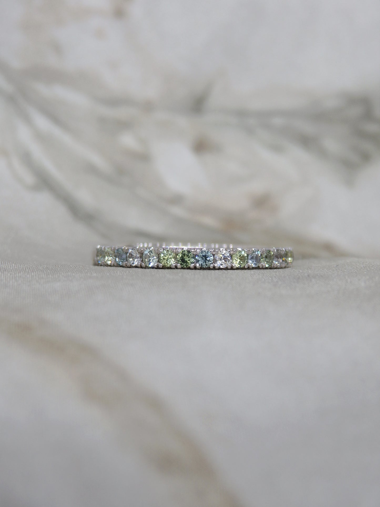 Multi tone pastel green, blue, yellow and white  diamond cut sparkly sapphires micro-pave set in 18ct white gold wedding band or eternity ring