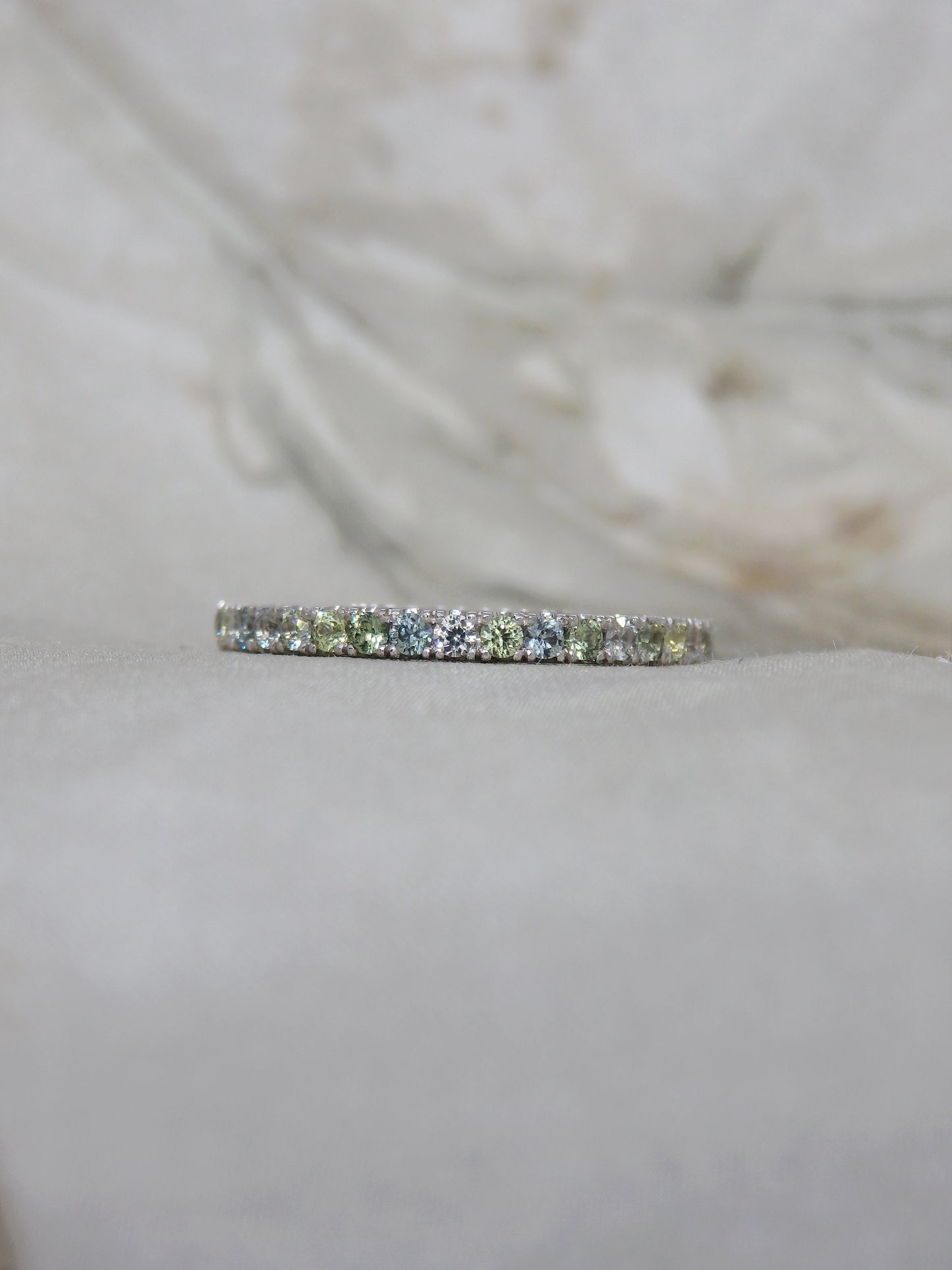 Multi tone pastel green, blue, yellow and white sapphires micro-pave set in 18ct white gold wedding band or eternity ring