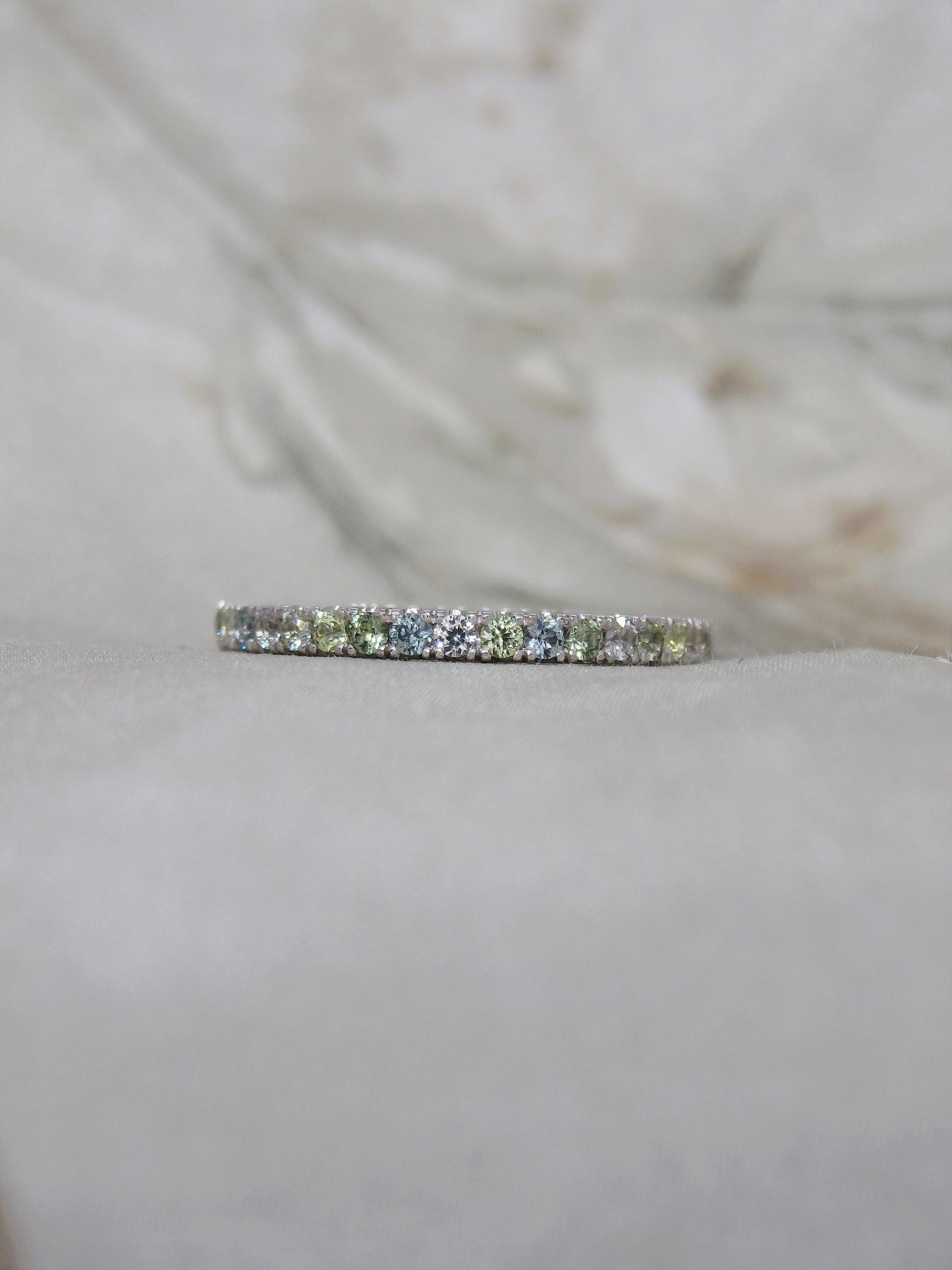 Multi tone pastel green, blue, yellow and white sapphires micro-pave set in 18ct white gold wedding band or eternity ring