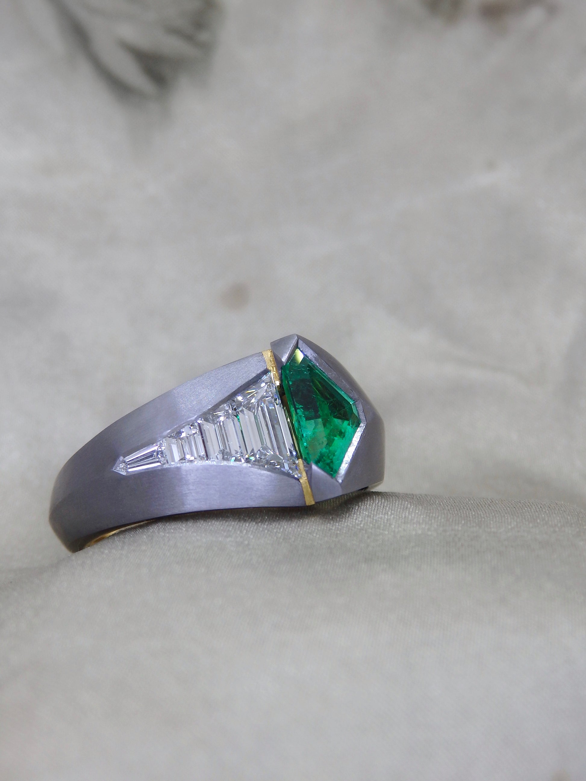 Australian Award-winning ring Caiman. A tantalum unisex engagement or dress ring with 18ct and 22ct yellow gold details with a geometric shield cut Colombian Emerald and tapering sort deco step cut trapezoidal and bullet cut natural diamonds