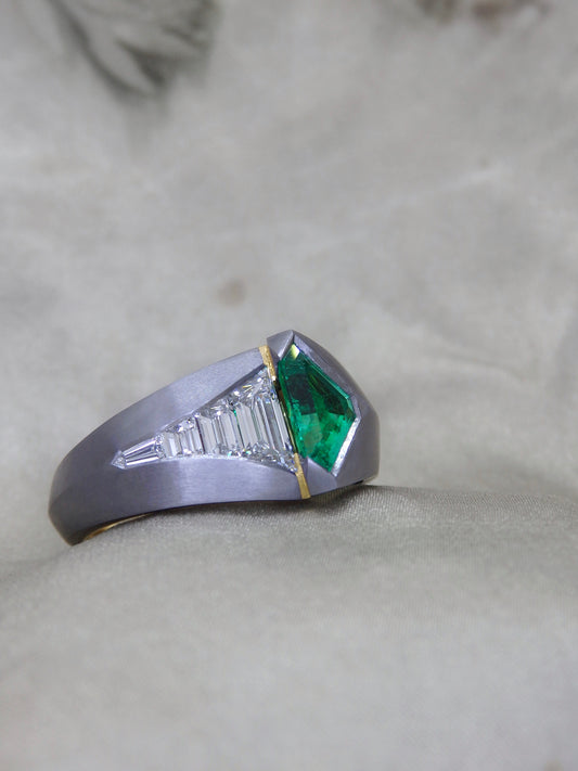 Australian Award-winning ring Caiman. A tantalum unisex engagement or dress ring with 18ct and 22ct yellow gold details with a geometric shield cut Colombian Emerald and tapering sort deco step cut trapezoidal and bullet cut natural diamonds